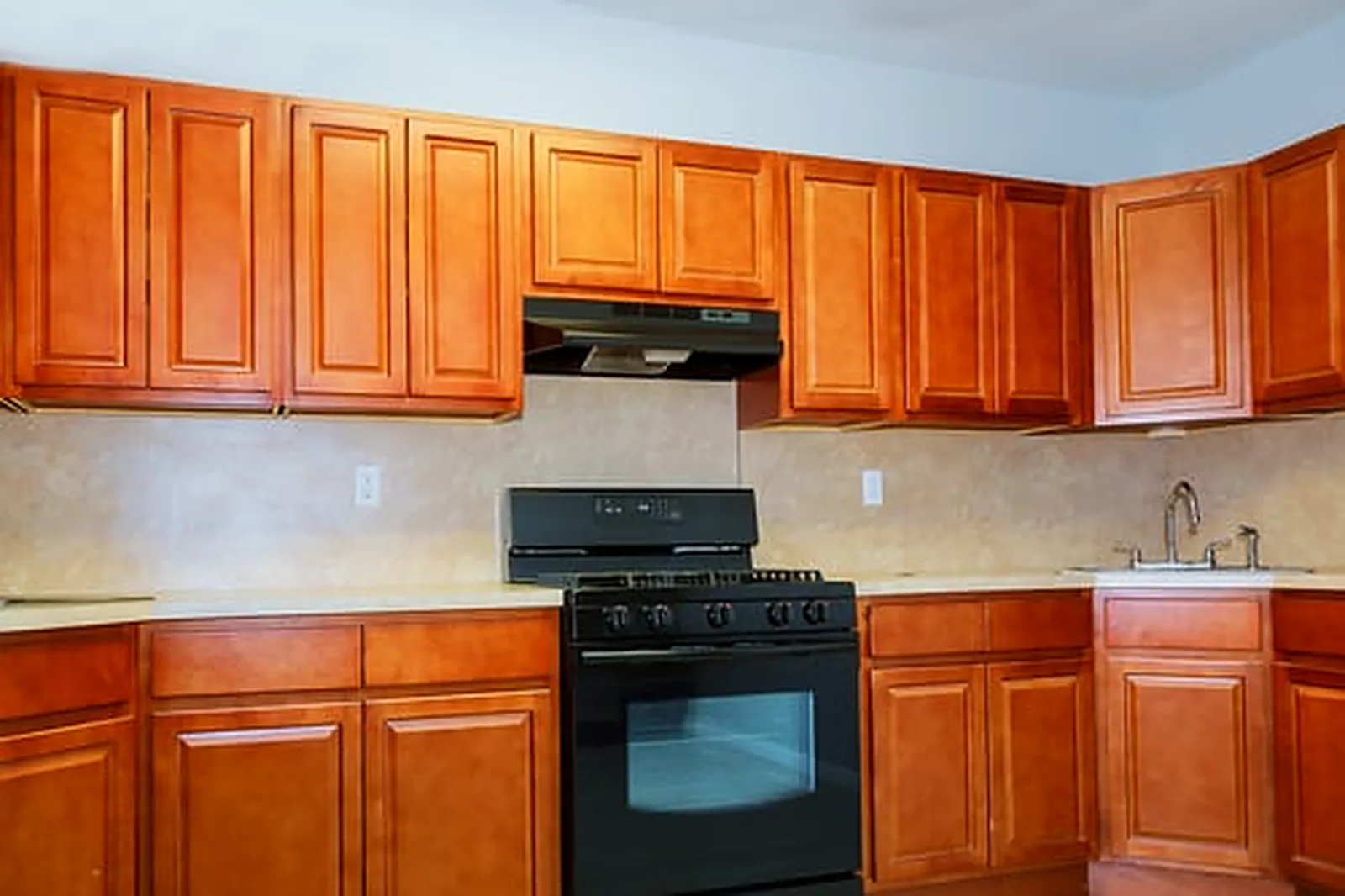 Dated honey-oak kitchen cabinets ready for a choice between cabinet refinishing and full replacement